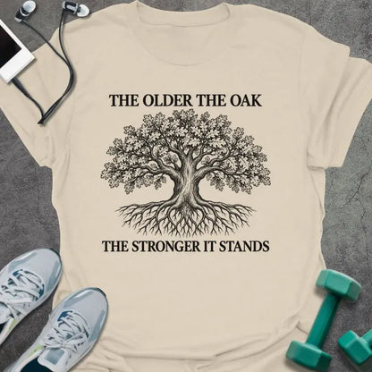 Natural t-shirt printed with "THE OLDER THE OAK, THE STRONGER IT STANDS" in black, with a drawing of an oak tree and its roots