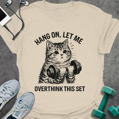Cream t-shirt printed with "Hang on, Let Me Overthink This Set", with a cat holding dumbbells