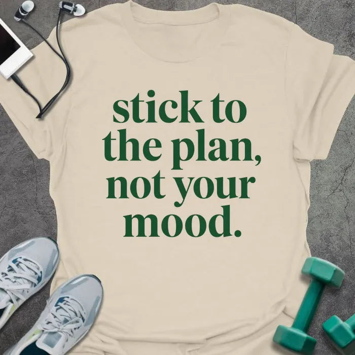 Natural t-shirt printed with "stick to the plan, not your mood." in green