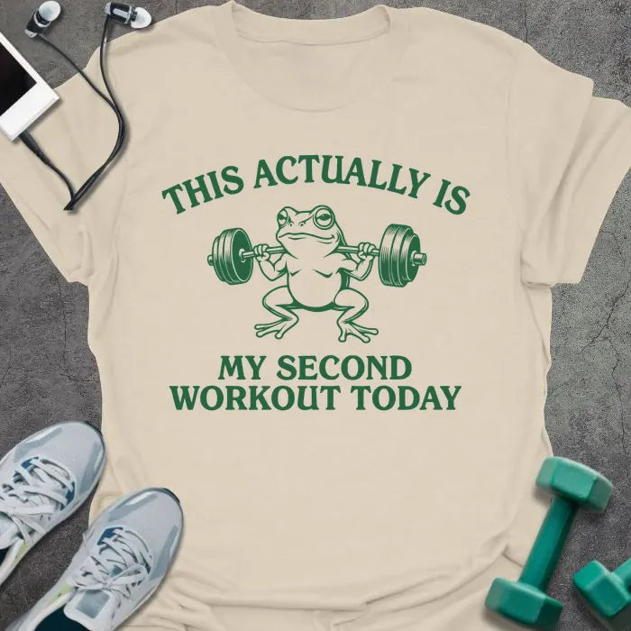 Cream t-shirt printed with "This Actually is my Second Workout Today" in green, with an illustration of a frog lifting barbell