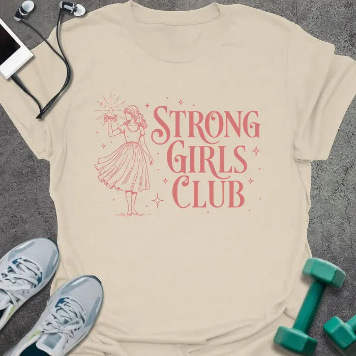 Cream t-shirt printed with "Strong Girls Club" in pink, with a girl illustration and sparkles