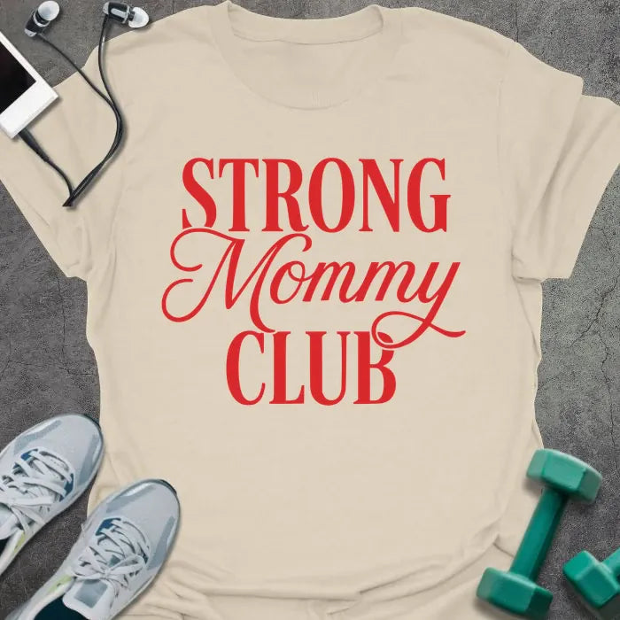 Cream t-shirt printed with "STRONG Mommy CLUB" in red and white, with a decorative script flourish on 'Mommy'
