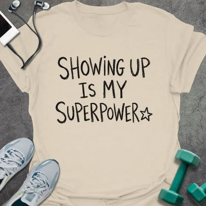 Natural t-shirt printed with "SHOWING UP IS MY SUPERPOWER" in black handwritten lettering, with a star outline