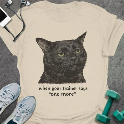 Cream t-shirt printed with "when your trainer says "one more", with a realistic unamused black cat portrait