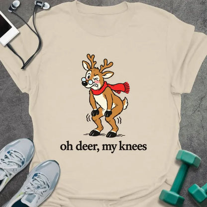 Natural t-shirt printed with "oh deer, my knees" in black, with a vintage cartoon reindeer in glasses and a red scarf holding its knees