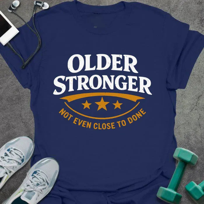 Navy t-shirt printed with "Older Stronger Not Even Close to Done" in white and orange, with a scoreboard showing three stars