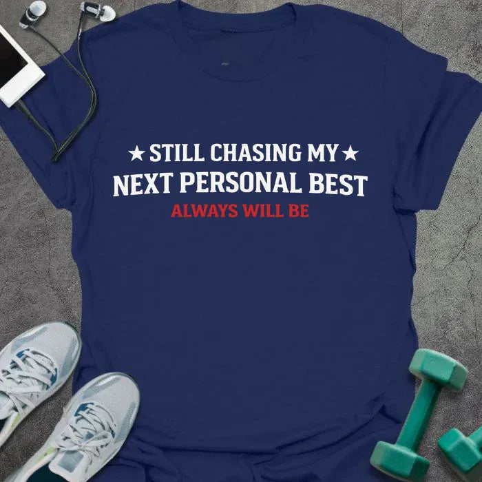 Navy t-shirt printed with "Still Chasing my Next Personal Best Always Will Be" in white and red