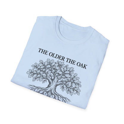 Folded light blue t-shirt printed with "THE OLDER THE OAK, THE STRONGER IT STANDS" in black, with a drawing of an oak tree and its roots