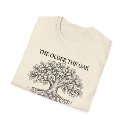 Folded natural t-shirt printed with "THE OLDER THE OAK, THE STRONGER IT STANDS" in black, with a drawing of an oak tree and its roots