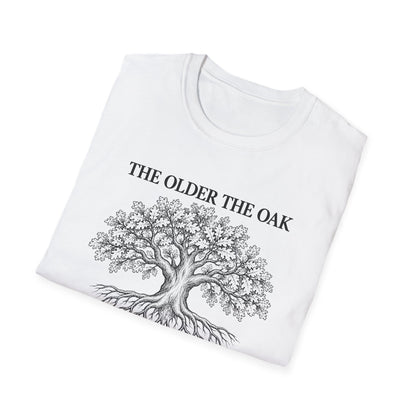 Folded white t-shirt printed with "THE OLDER THE OAK, THE STRONGER IT STANDS" in black, with a drawing of an oak tree and its roots