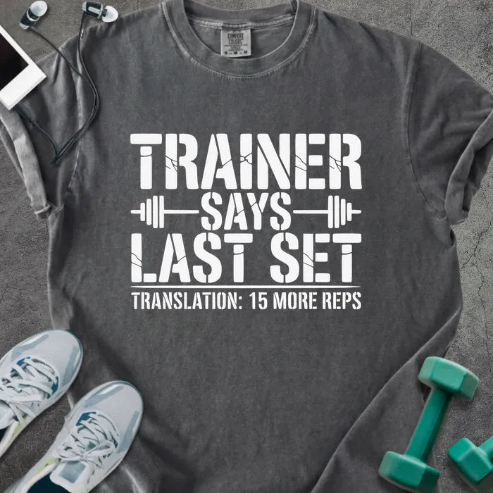 Pepper t-shirt printed with "Trainer Says Last Set Translation: 15 More Reps" in white, with a barbell graphic