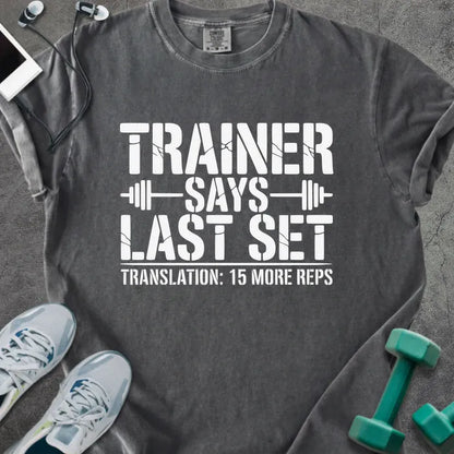 Pepper t-shirt printed with "Trainer Says Last Set Translation: 15 More Reps" in white, with a barbell graphic