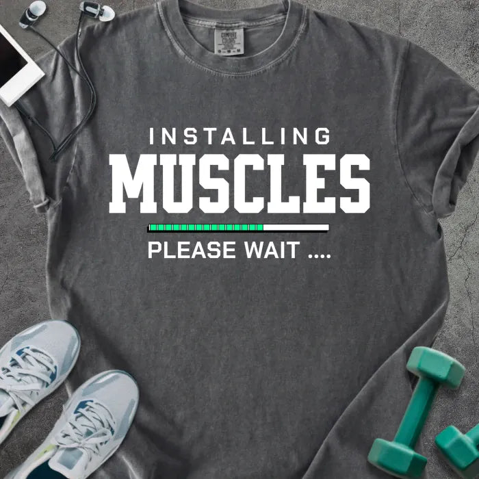 Pepper t-shirt printed with "Installing Muscles Please Wait ...." in white and multicolor, with a loading bar