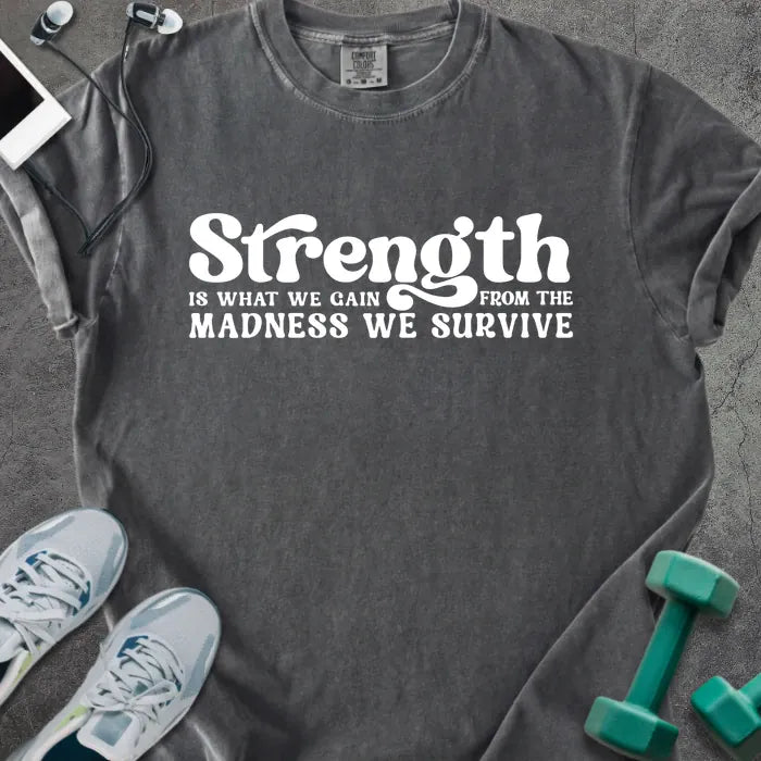 Pepper t-shirt printed with "Strength is WHAT WE GAIN FROM THE MADNESS WE SURVIVE" in white