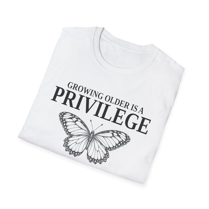 Folded white t-shirt printed with "GROWING OLDER IS A PRIVILEGE, GROWING STRONGER IS A CHOICE" in black, with a line-drawn butterfly