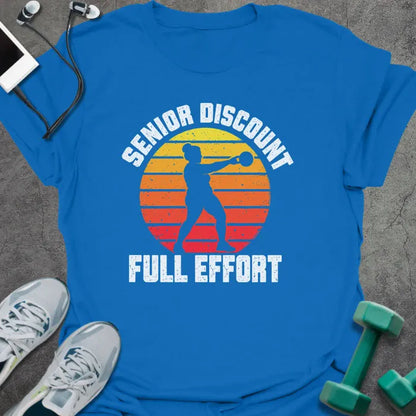 Royal blue t-shirt printed with "SENIOR DISCOUNT, FULL EFFORT" in white, with a woman swinging a kettlebell against a retro yellow, orange and red sunset