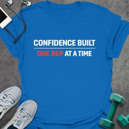 Royal blue t-shirt printed with "Confidence Built One Rep at a Time" in white and red