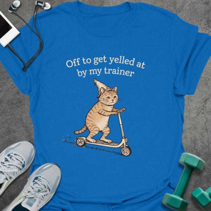 Royal blue t-shirt printed with "Off to get yelled at by my trainer" in tan, white, with a cat on a scooter