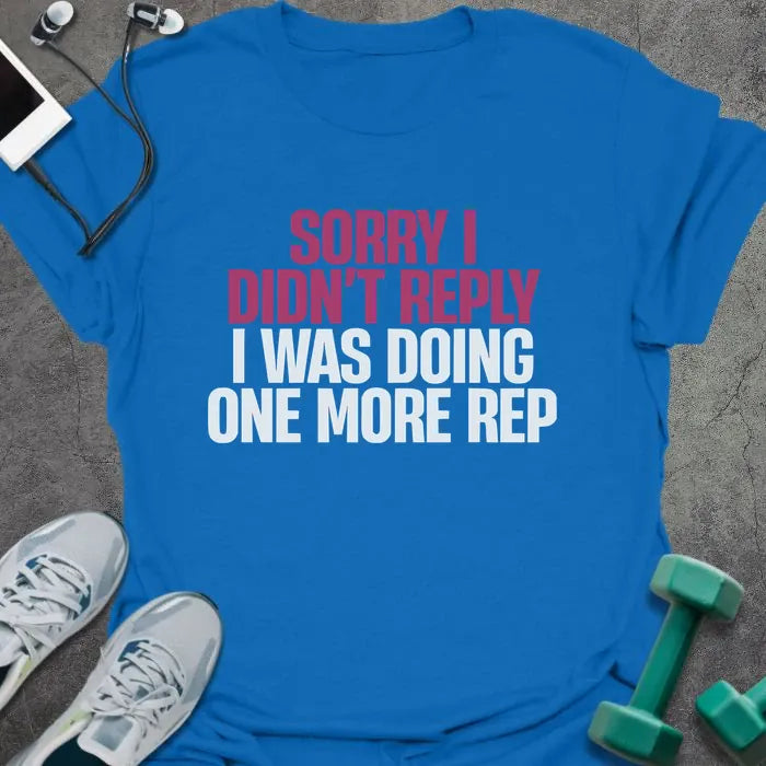 Royal blue t-shirt printed with "Sorry I Didn't Reply I Was Doing One More Rep" in white and pink