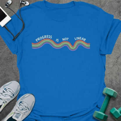 Royal blue t-shirt printed with "Progress is Not Linear" in white, rainbow, with a wavy rainbow line