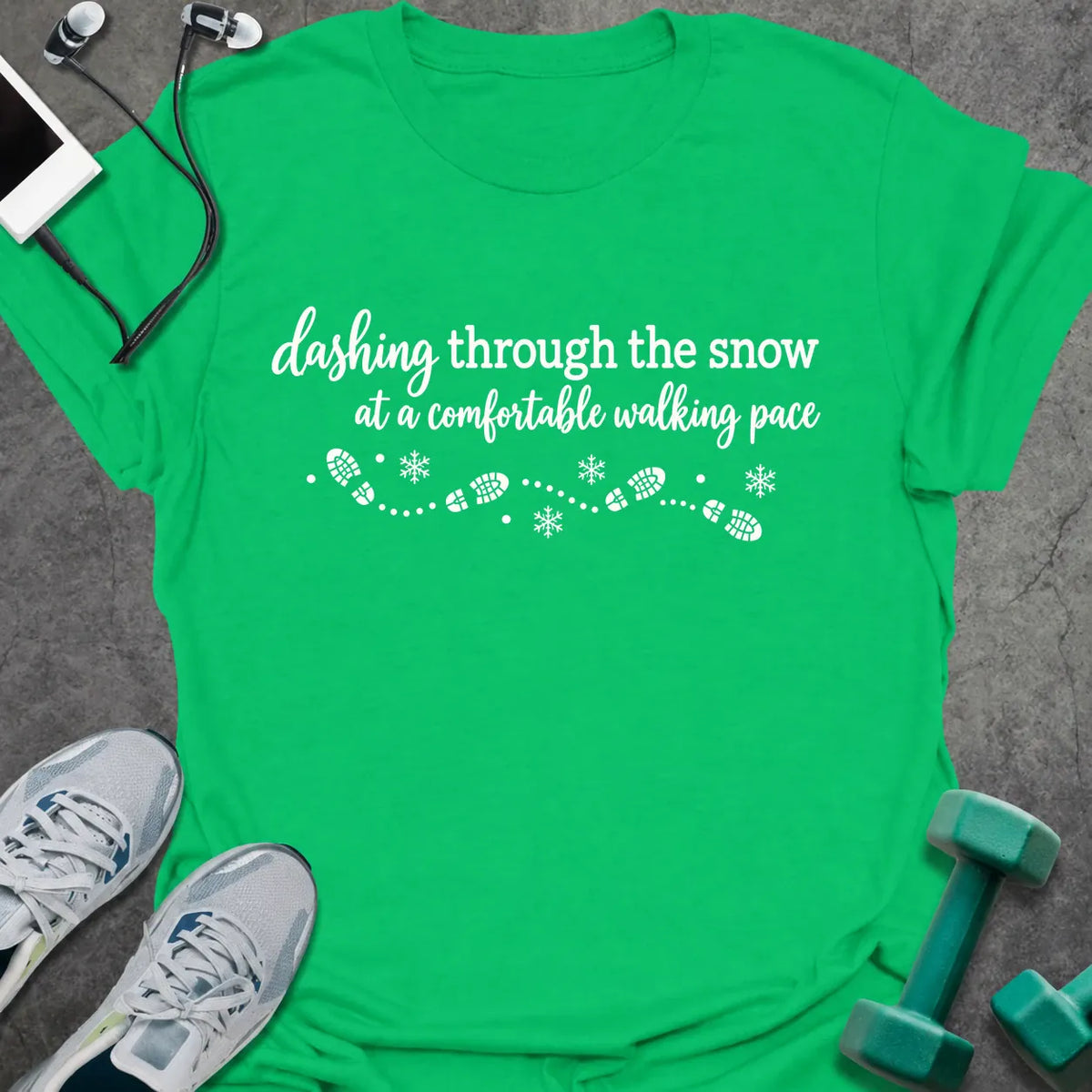 Irish green t-shirt printed with "dashing through the snow at a comfortable walking pace" in white, with a dotted trail of footprints and snowflakes