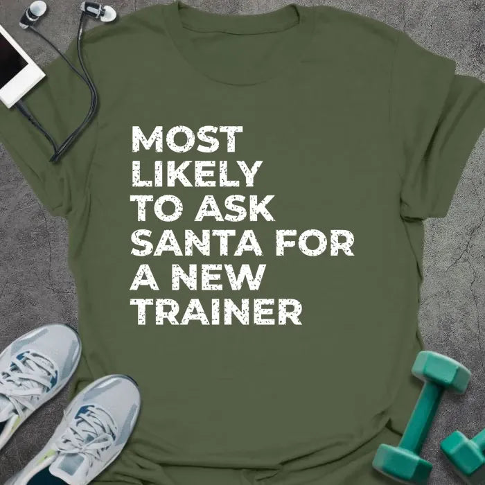 Military green t-shirt printed with "MOST LIKELY TO ASK SANTA FOR A NEW TRAINER" in white
