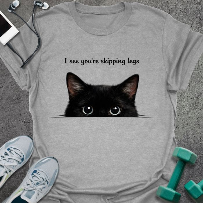 Sport grey t-shirt printed with "I see you're skipping legs", with a black cat peeking over the bottom edge of the text