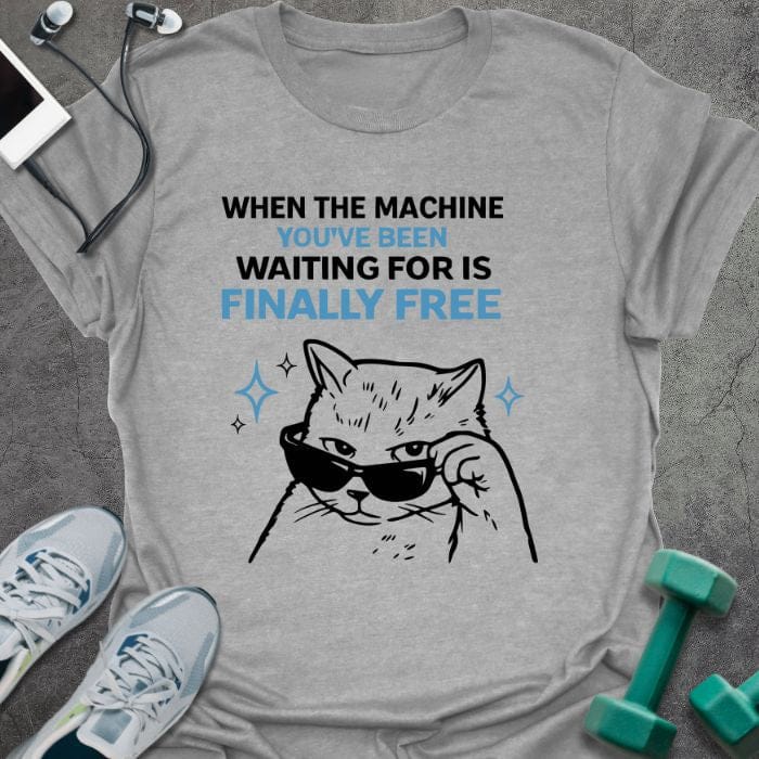 Sport grey t-shirt printed with "When the Machine You've Been Waiting for is Finally Free" in black, with an illustration of a cat wearing sunglasses