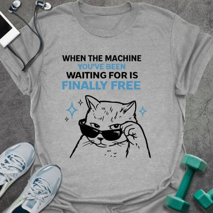 Sport grey t-shirt printed with "When the Machine You've Been Waiting for is Finally Free" in black, with an illustration of a cat wearing sunglasses