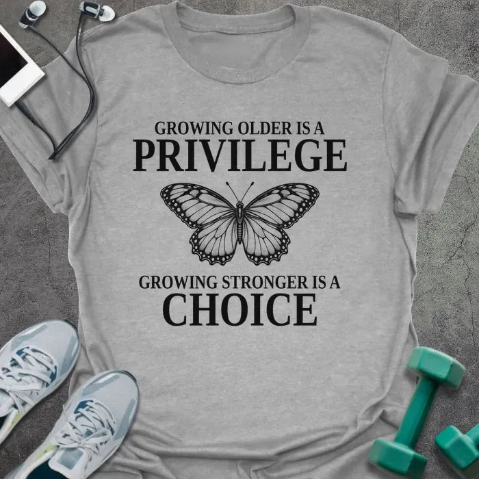 Sport grey t-shirt printed with "GROWING OLDER IS A PRIVILEGE, GROWING STRONGER IS A CHOICE" in black, with a line-drawn butterfly