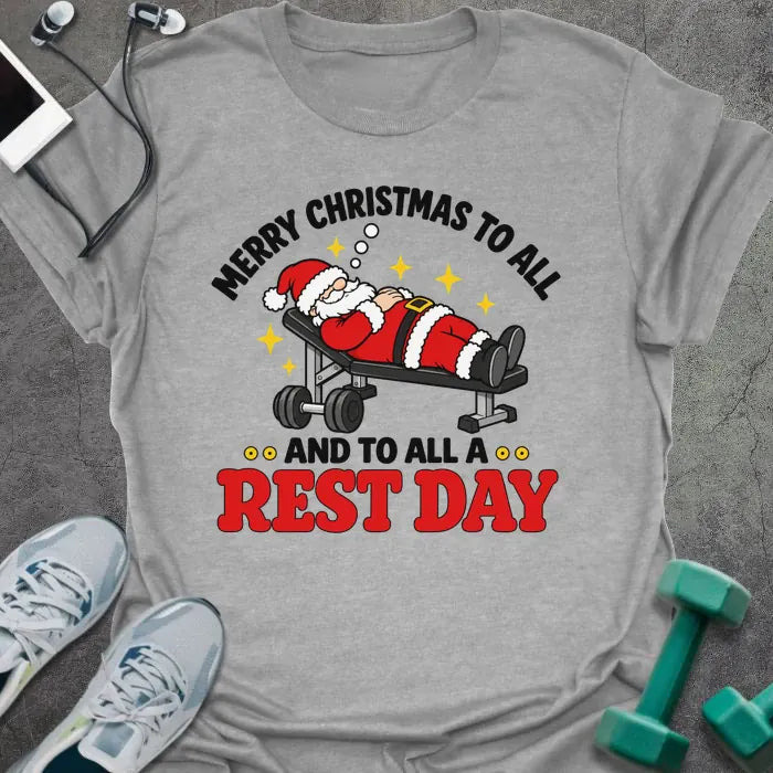 Sport grey t-shirt printed with "MERRY CHRISTMAS TO ALL AND TO ALL A REST DAY" in black and red, with Santa asleep on a weight bench
