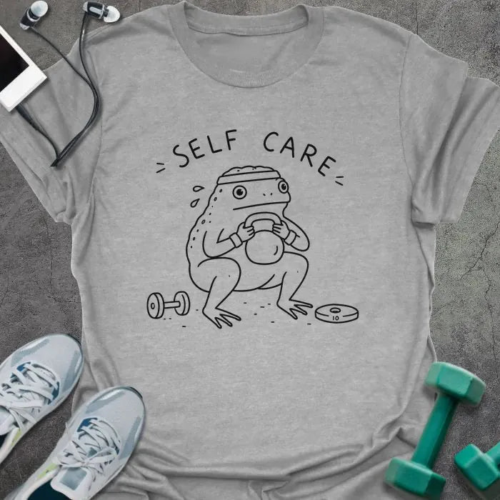 Sport Grey t-shirt printed with "= SELF CARE =" in black, with figure exercising with kettlebell and dumbbells
