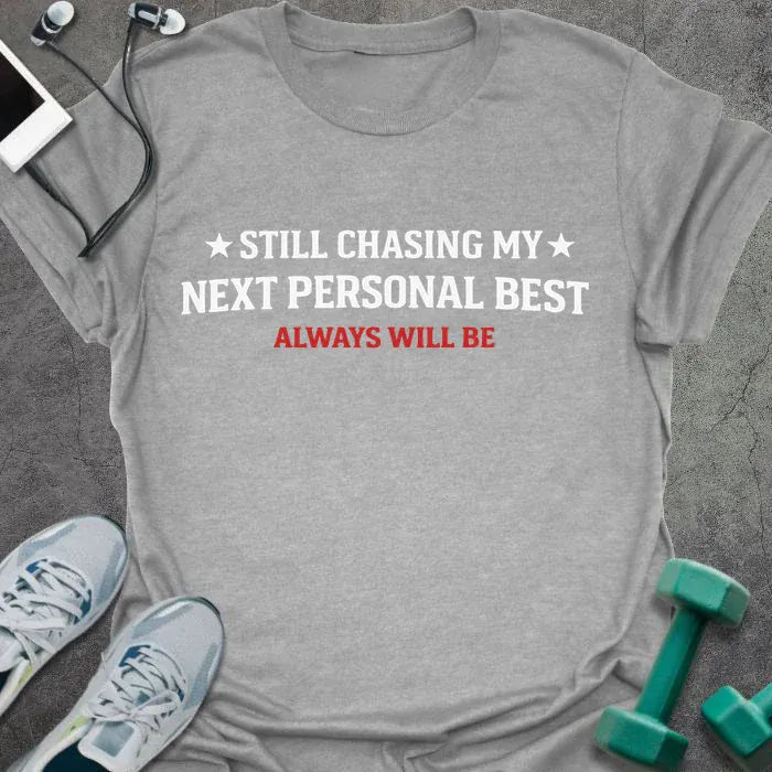 Sport grey t-shirt printed with "Still Chasing my Next Personal Best Always Will Be" in white and red