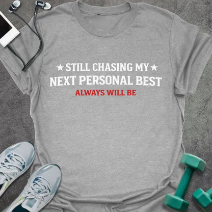 Sport grey t-shirt printed with "Still Chasing my Next Personal Best Always Will Be" in white and red