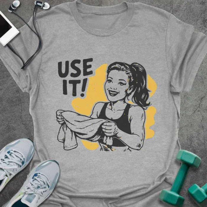 Sport grey t-shirt printed with "Use it!" in black and yellow, with a retro-style woman illustration holding a towel