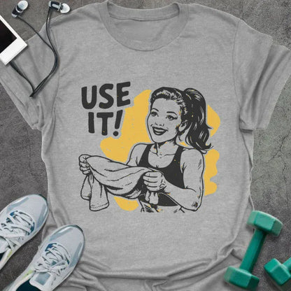 Sport grey t-shirt printed with "Use it!" in black and yellow, with a retro-style woman illustration holding a towel