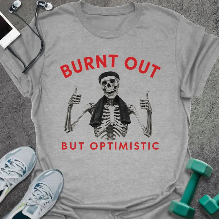 Sport Grey t-shirt printed with "BURNT OUT but OPTIMISTIC" in red and black, with skeleton with dumbbells