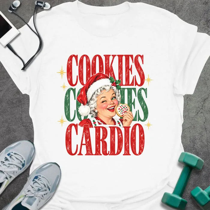 White t-shirt printed with "COOKIES COOKIES CARDIO" in red and green, with a vintage Mrs. Claus in a Santa hat winking and holding a frosted cookie