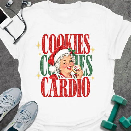 White t-shirt printed with "COOKIES COOKIES CARDIO" in red and green, with a vintage Mrs. Claus in a Santa hat winking and holding a frosted cookie