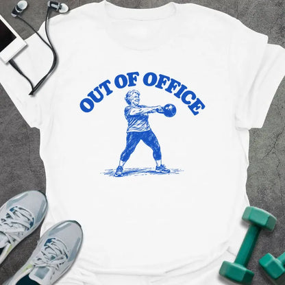 White t-shirt printed with "OUT OF OFFICE" in blue, with a sketch of an older woman swinging a kettlebell