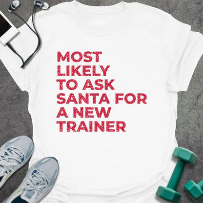 White t-shirt printed with "MOST LIKELY TO ASK SANTA FOR A NEW TRAINER" in red