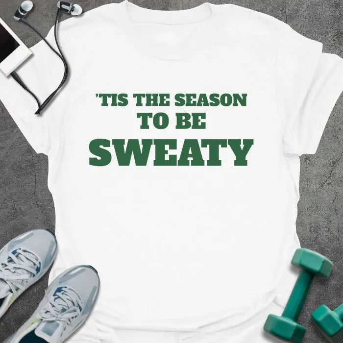 White t-shirt printed with "'TIS THE SEASON TO BE SWEATY" in green