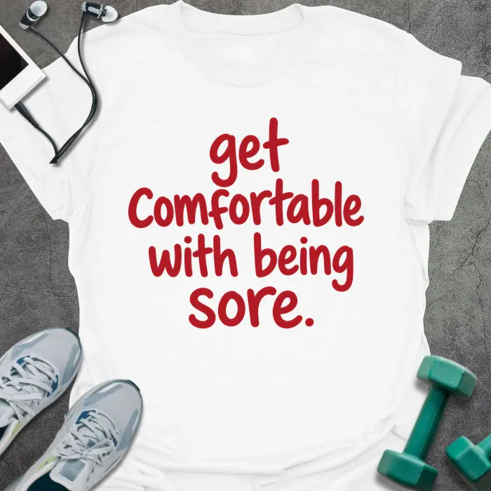 White t-shirt printed with "get comfortable with being sore." in red