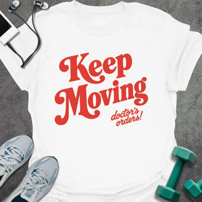 White t-shirt printed with "Keep Moving doctor's orders!" in red script lettering