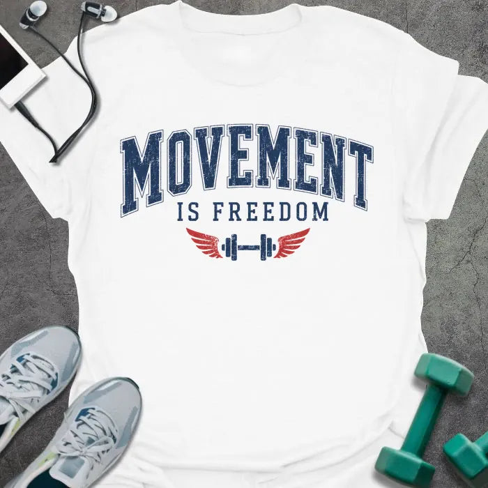 White t-shirt printed with "Movement is Freedom" in blue and red, with red winged barbells