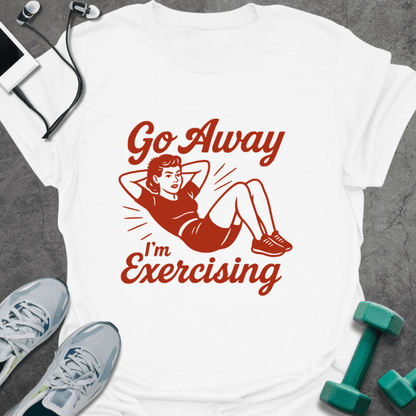 White t-shirt printed with "Go Away I'm Exercising" in red and brown, with an illustration of a woman doing a sit-up