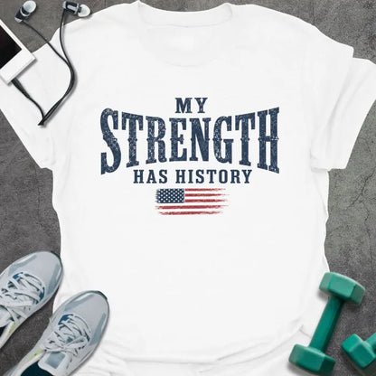 White t-shirt printed with "My Strength Has History" in blue and red, with a distressed American flag