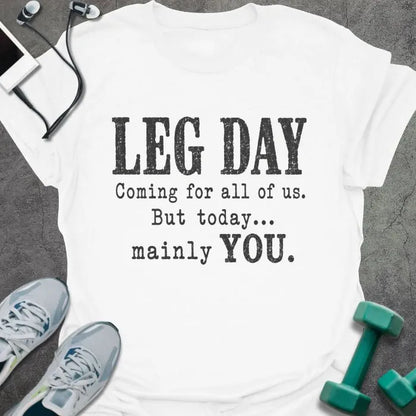 White T-shirt printed with "LEG DAY Coming for all of us. But today... mainly YOU." in brown