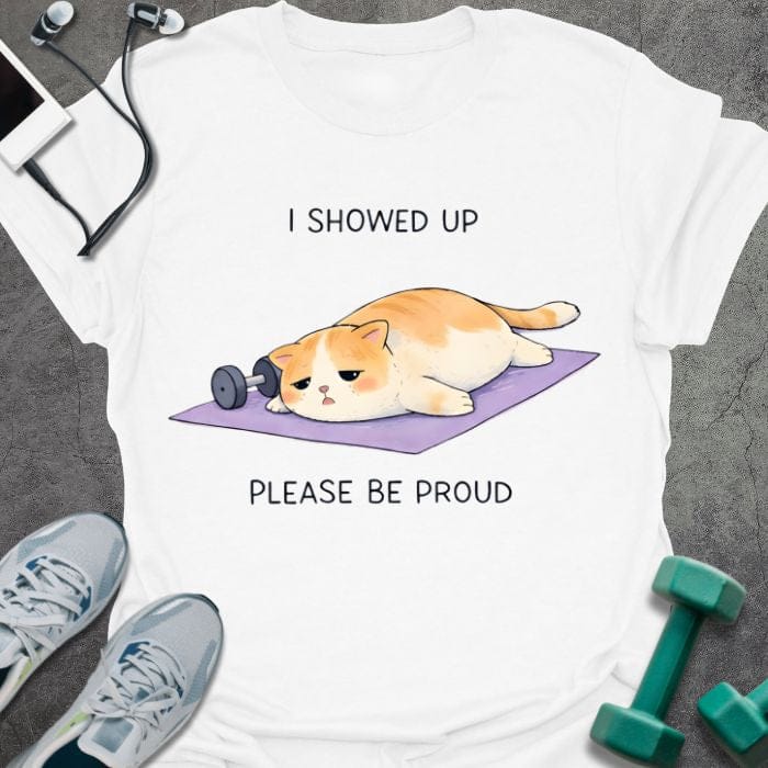 White t-shirt printed with "I Showed Up Please Be Proud" in orange, white, purple, with an orange and white cat on a purple yoga mat
