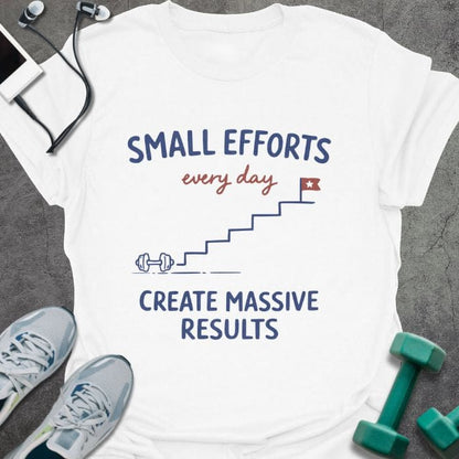 White t-shirt printed with "SMALL EFFORTS every day CREATE MASSIVE RESULTS" in red and blue, with stairs and flag illustration